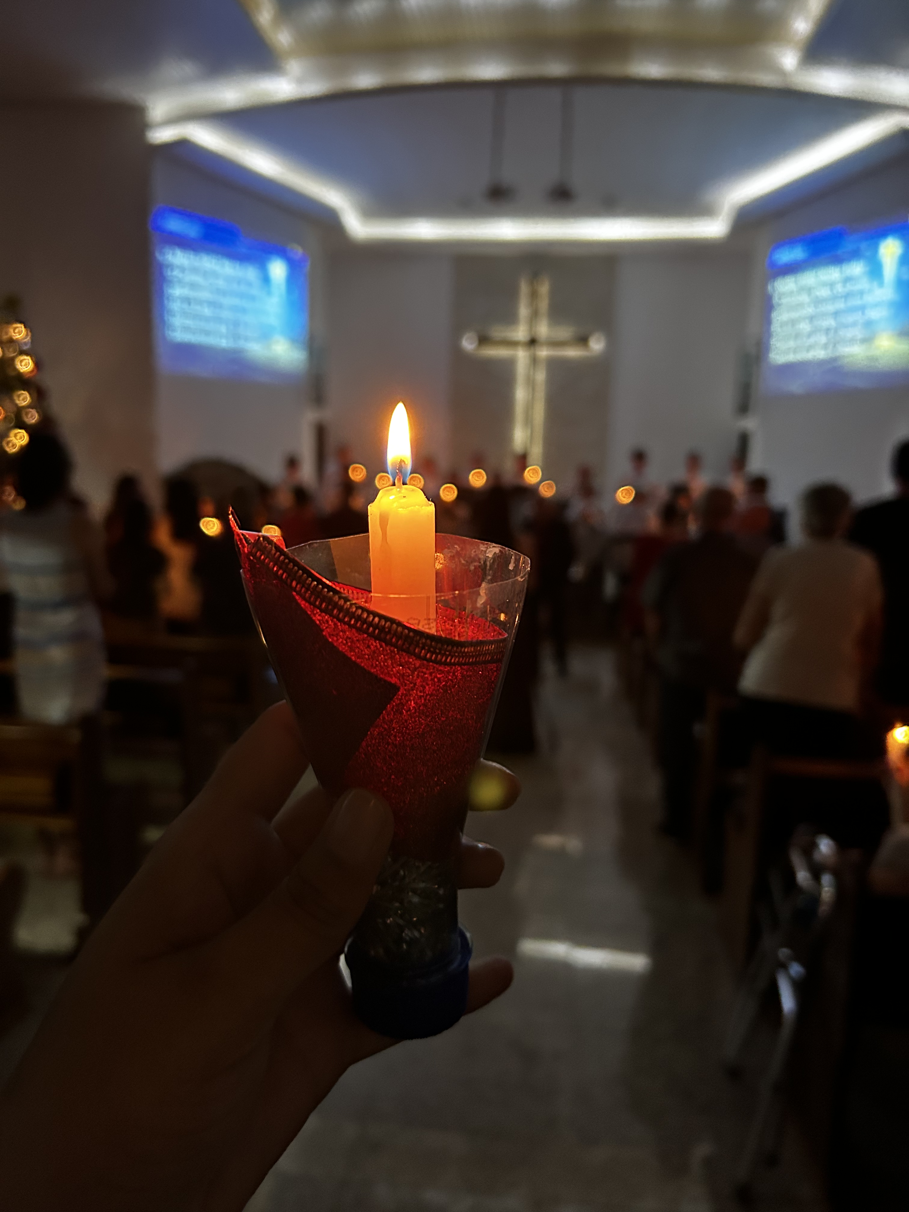 Interior da igreja iluminado por vela no altar